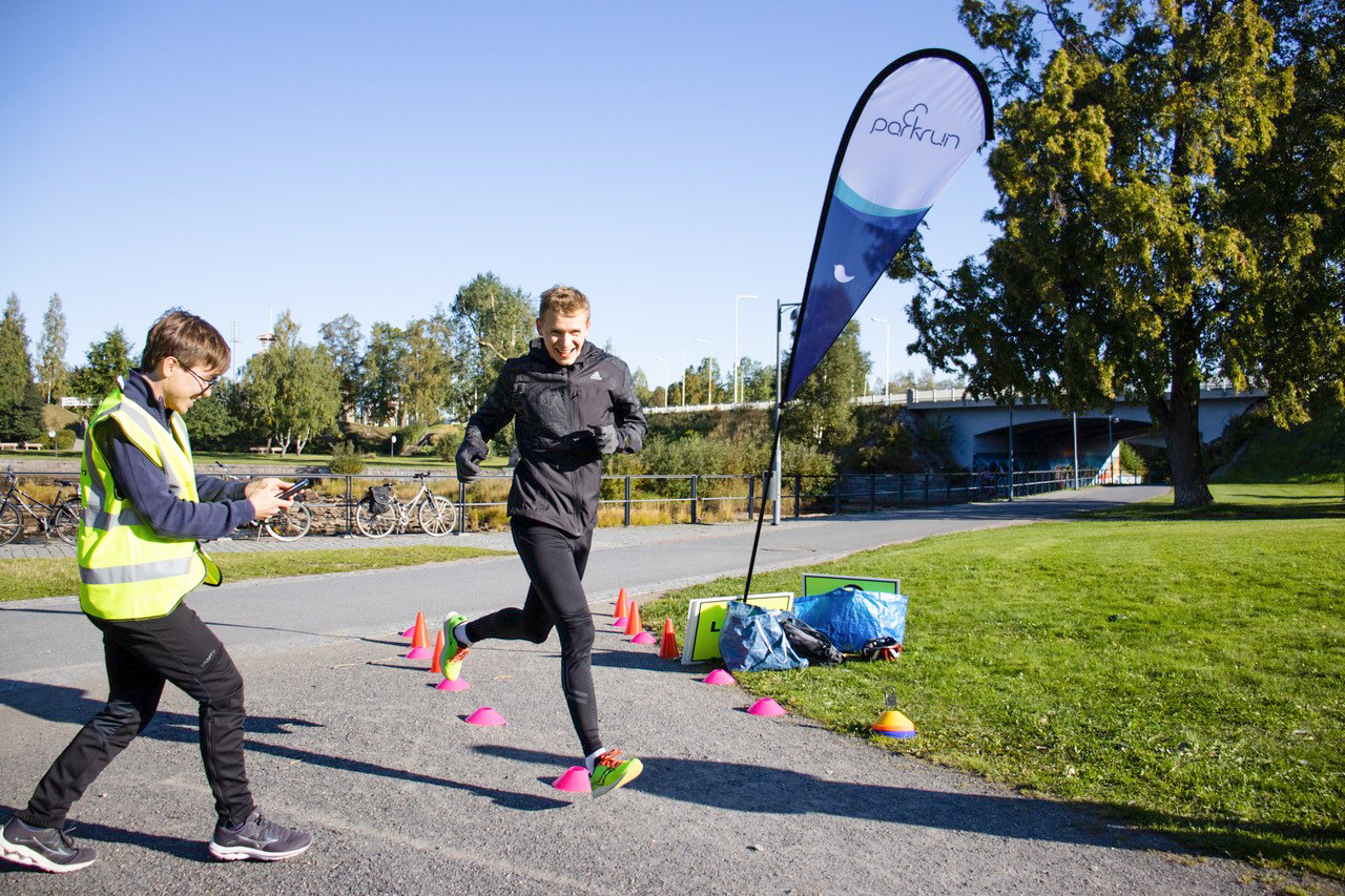 Juoksija ja ajanottaja parkrunissa.