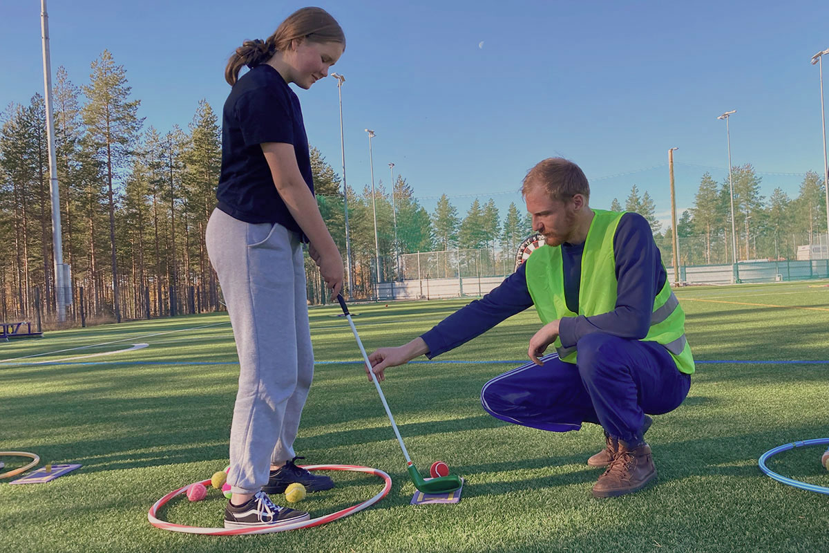 Sampo Alatulkkila Oulun Golfkerho ry:stä opastaa Senja Siltakoskea lyöntitekniikassa.