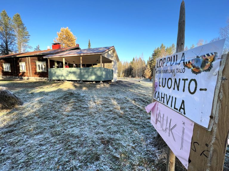 Luontokahvila-kyltti, taustalla rakennus.