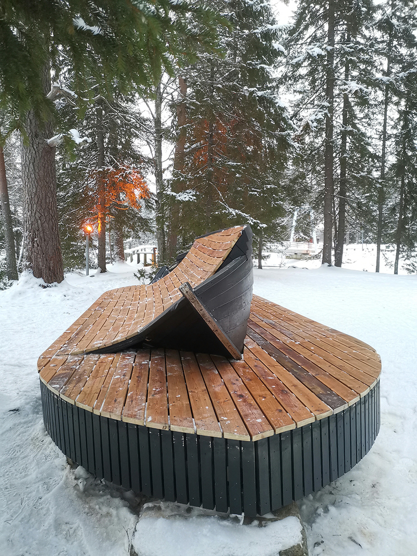 Veneestä tehty penkki talvimaisemassa.