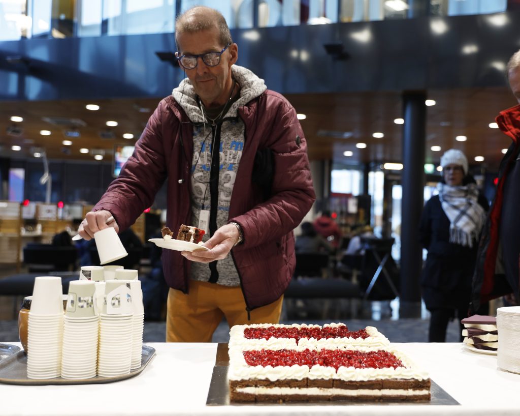 Mies ottaa täytekakkua seisovasta pöydästä.