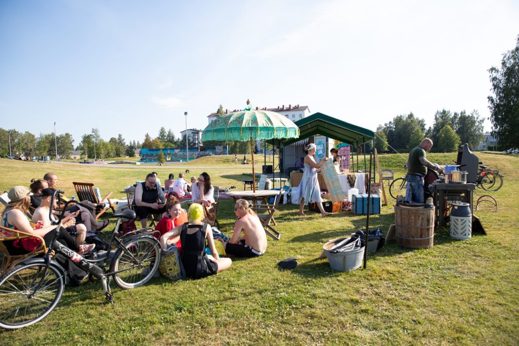 Ihmisiä piknik-tapahtumassa aurinkoisessa puistossa.