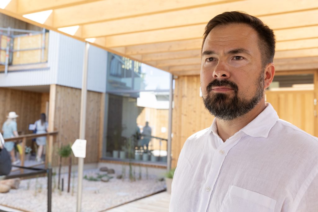 Mies valkoisessa paidassa puolilähikuvassa.