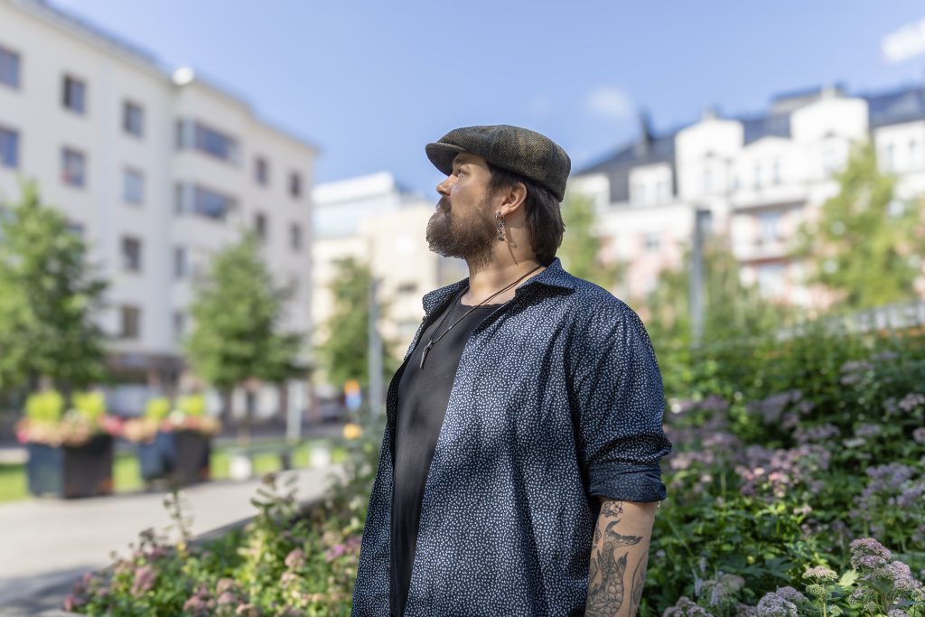 Mies katselee yläviistoon aukiolla keskustassa.
