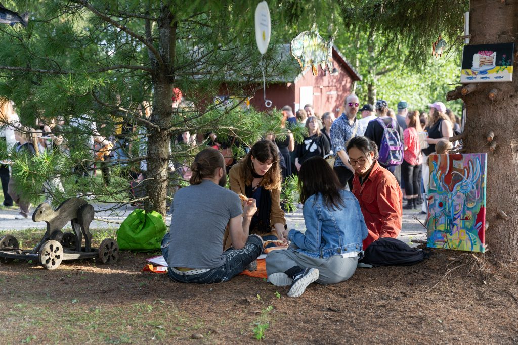 Ihmisiä istuskelemassa pihapiirissä.