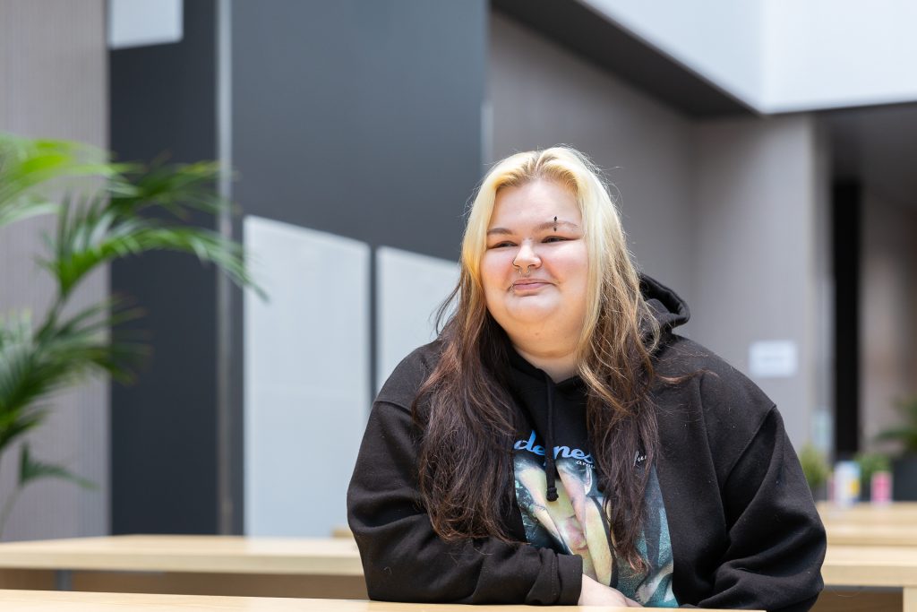 Nuori vaaleahiuksinen nainen puolilähikuvassa.