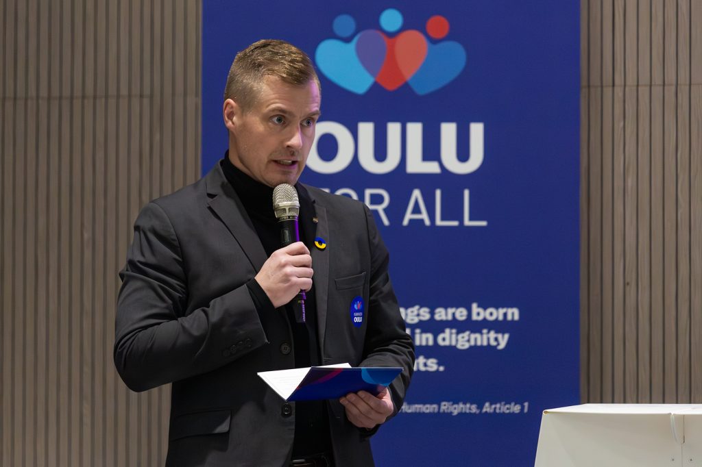 Mies puhuu mikrofoniin.