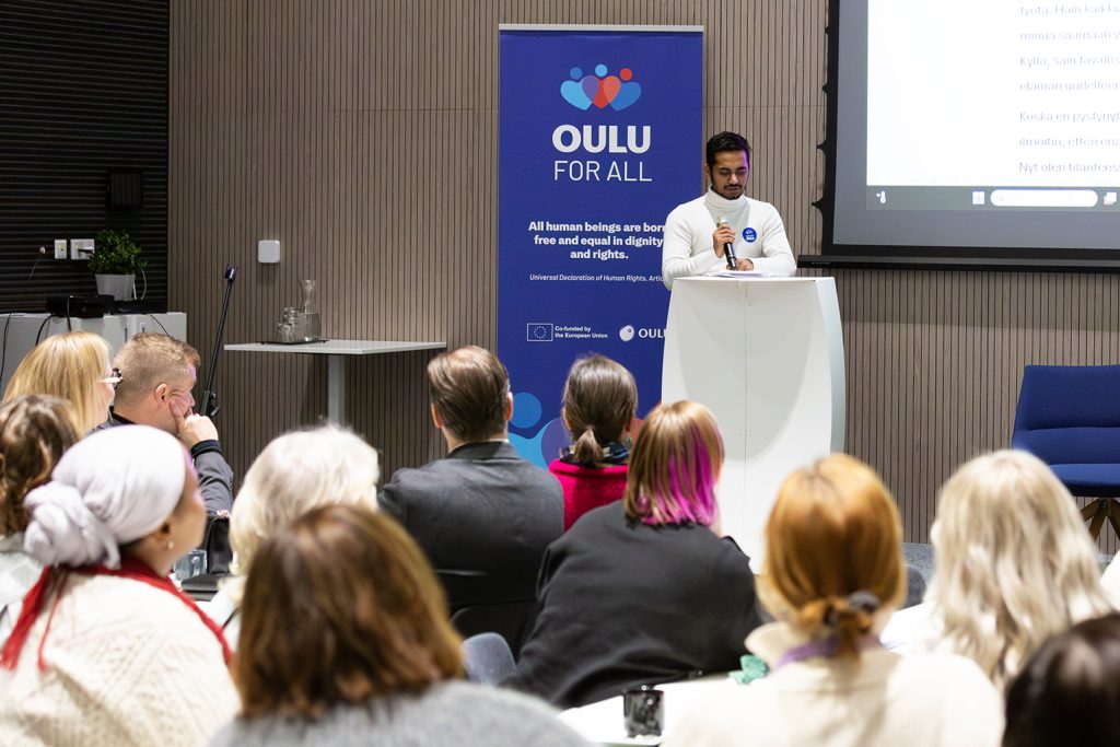 Aasialainen mies puhuu yleisölle.