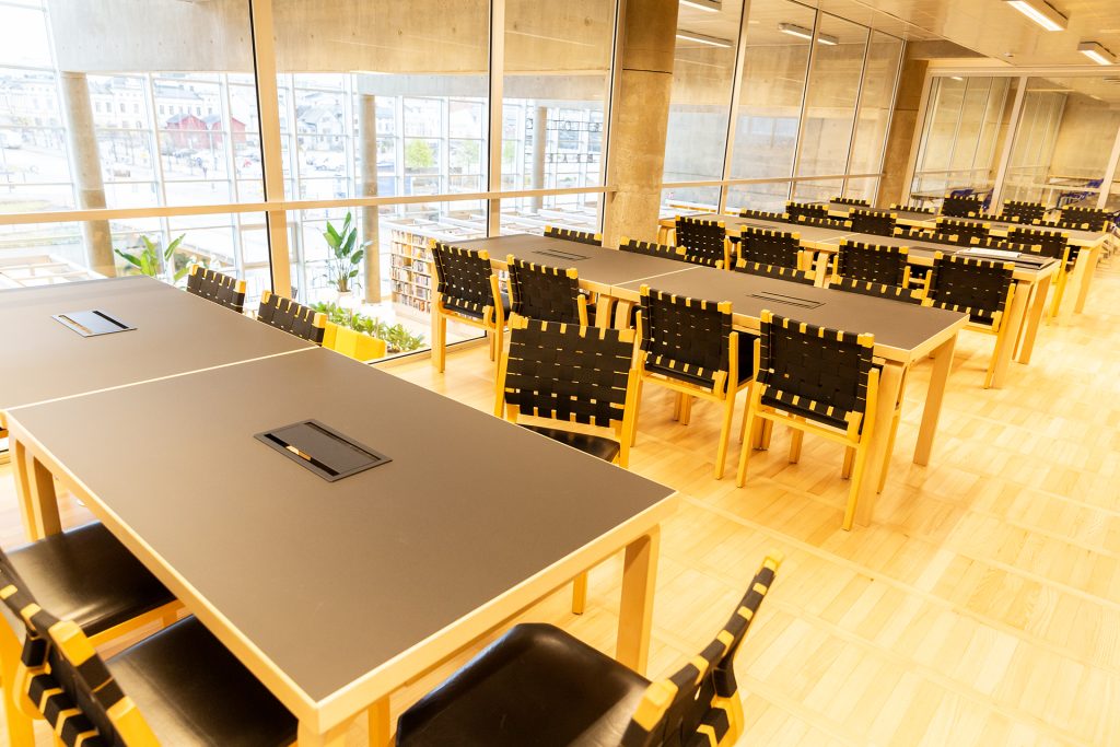 Kirjaston lukusalin pöytiä.