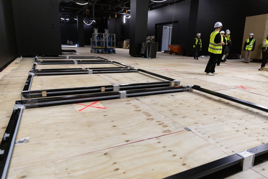 Rakenteilla oleva suuri museosali, sivustalla ihmisiä työmaavarusteissa.