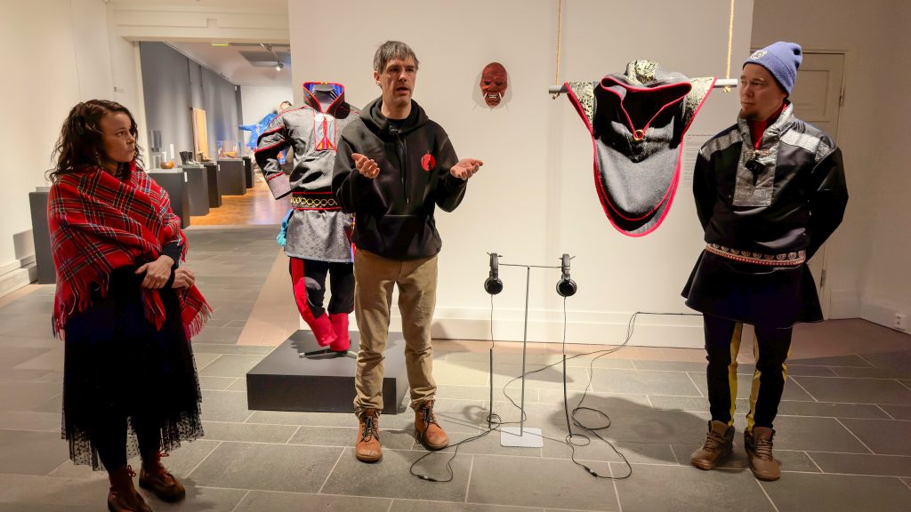 Nainen ja kaksi miestä taideinstallaation edessä.