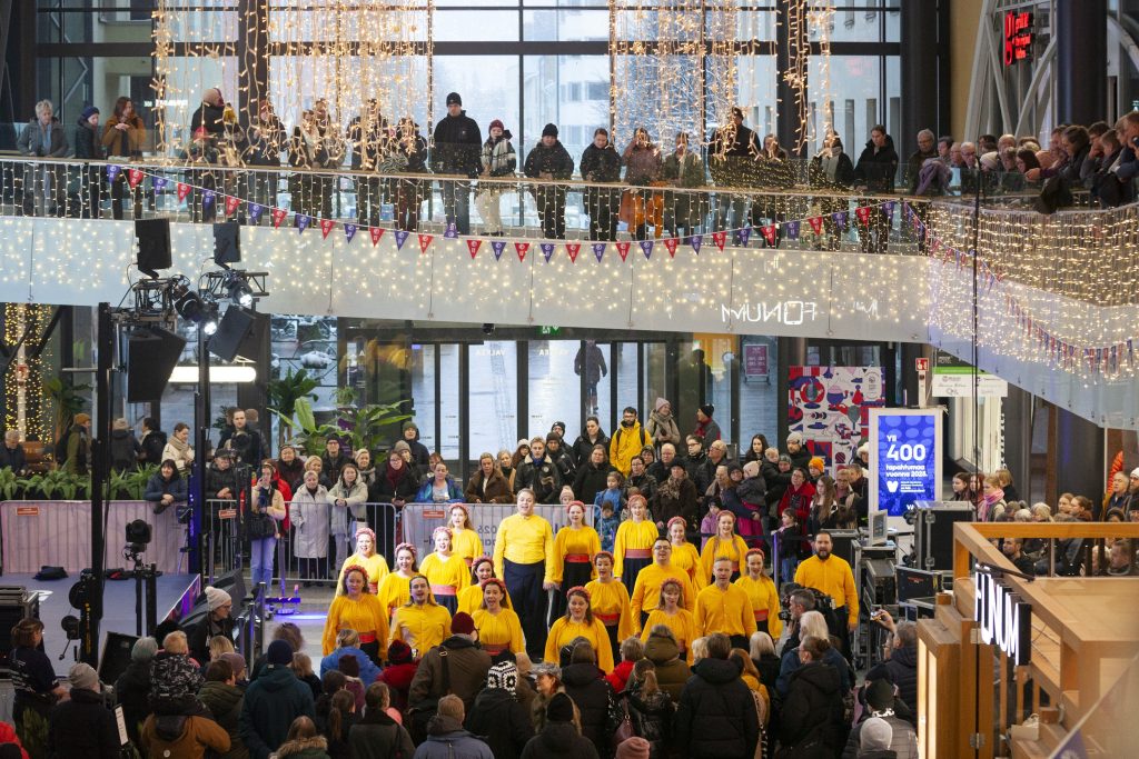 Yleisö seuraa kansantanssiryhmän esitystä kauppakeskuksessa.