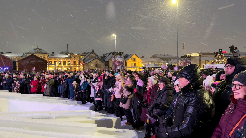 Väkijoukko lumisateessa.