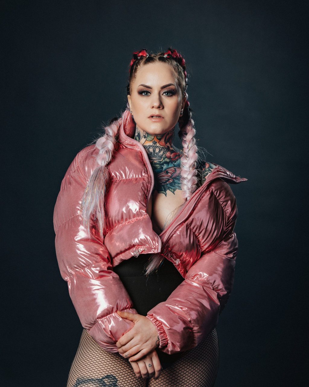 Nuori nainen poseeraa pinkissä toppatakissa.