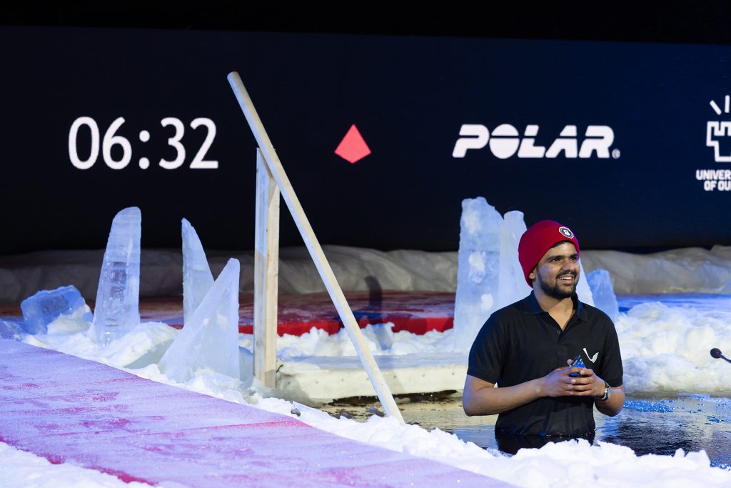 Mies puhuu avannossa, taustalla kellotaulu.