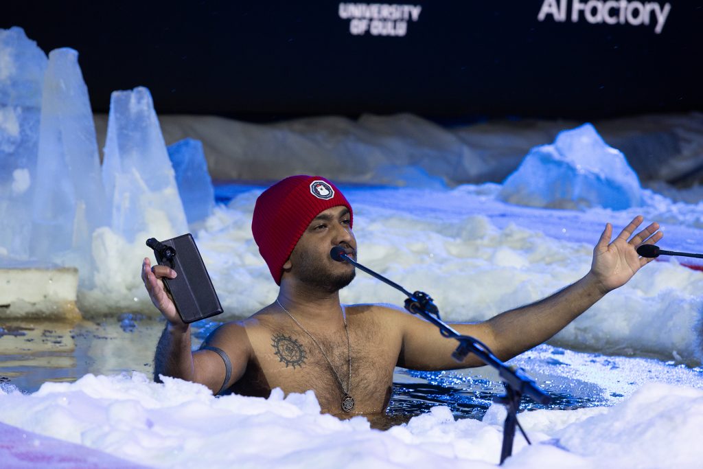 Pipopäinen mies avannossa, toisessa kädessä kännykkä.