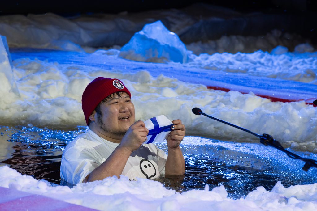 Japanilainen mies avannossa kädessään pieni Suomen lippu.