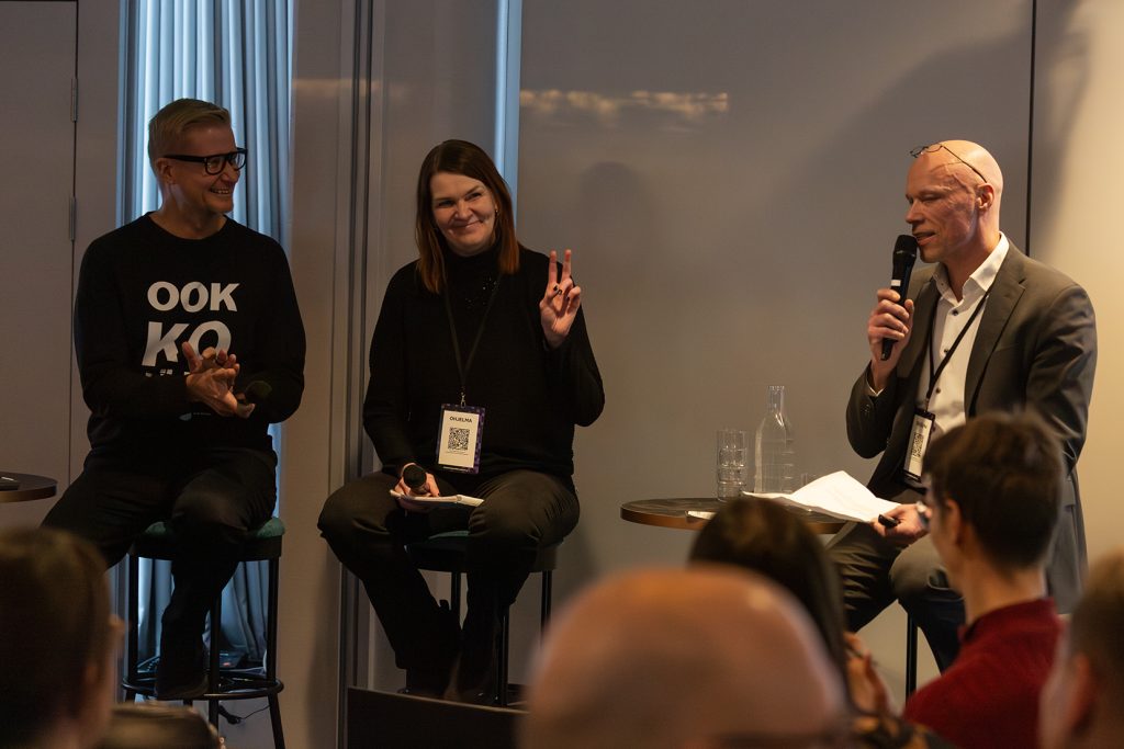 Kaksi miestä ja yksi nainen paneelikeskustelussa.