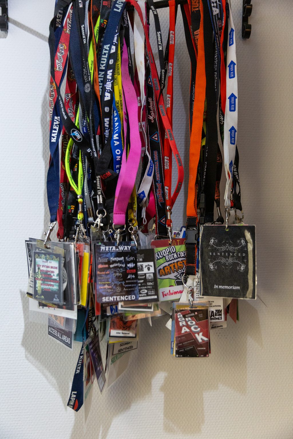 Kaulanauhoissa olevia kulkulupia ripustettuna seinälle.