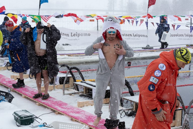 Riisuutuvia talviuimareita altaan reunalla.