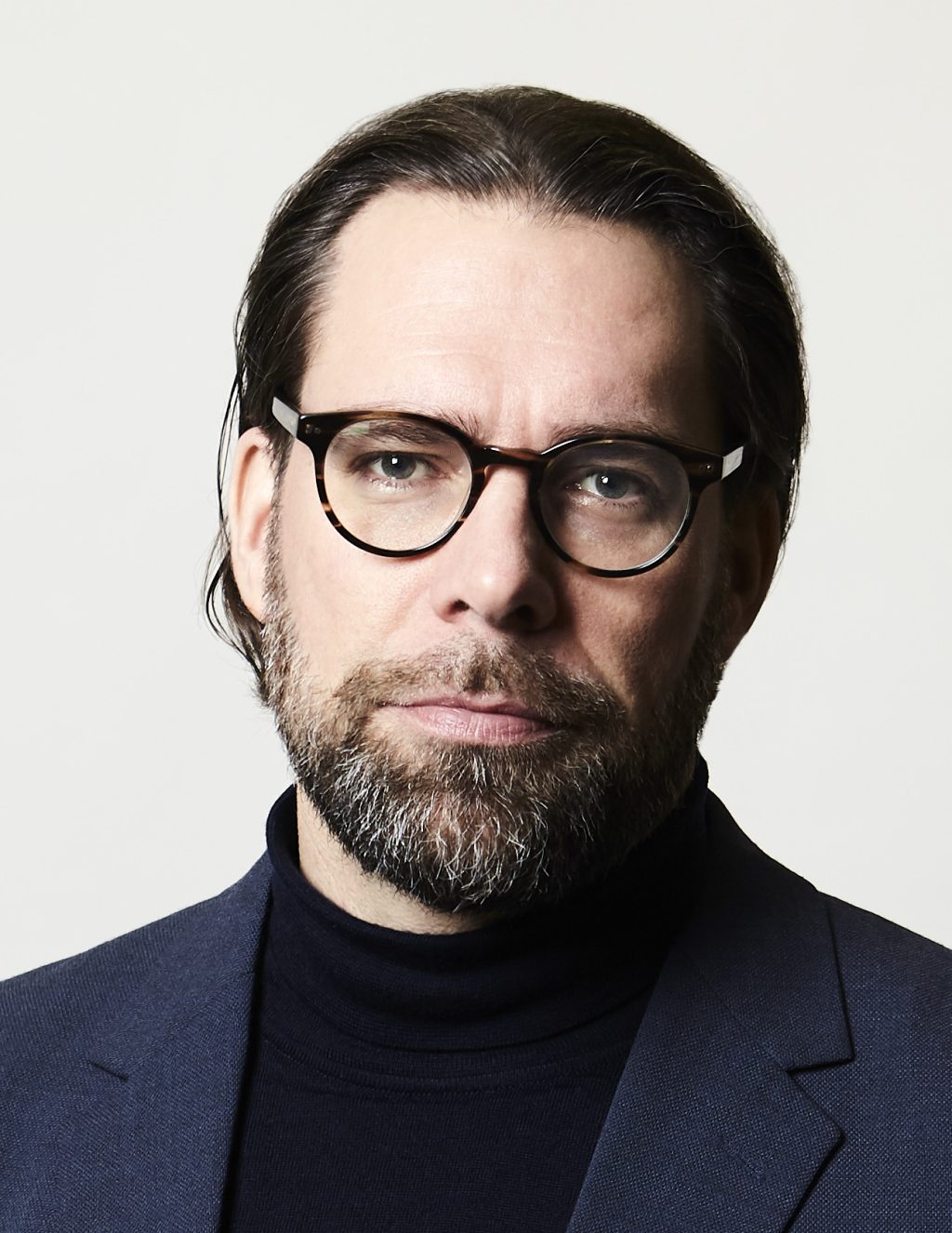 Passikuva silmälasipäisestä, parrakkaasta nuorehkosta miehestä