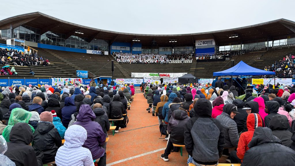 Yleisöä konsertissa sateisella stadionilla.