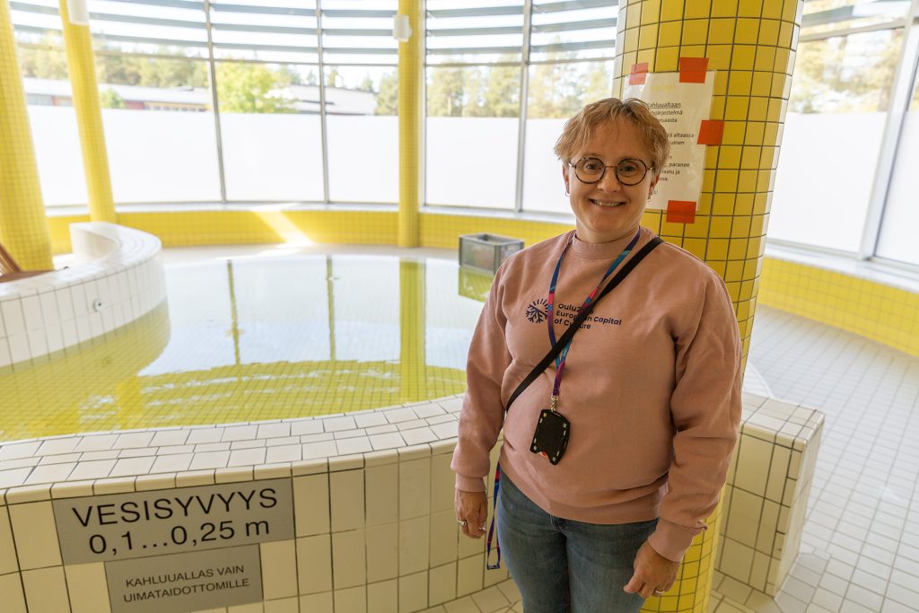 Nainen seisoo uimahallin kahluualtaan vedessä.