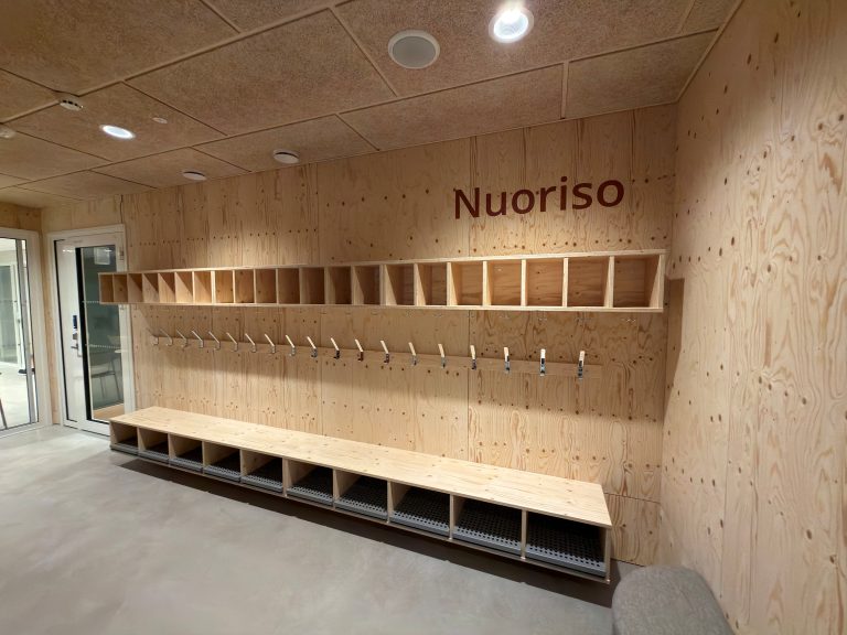 Nuoristotilan puupintainen naulakkkotila.