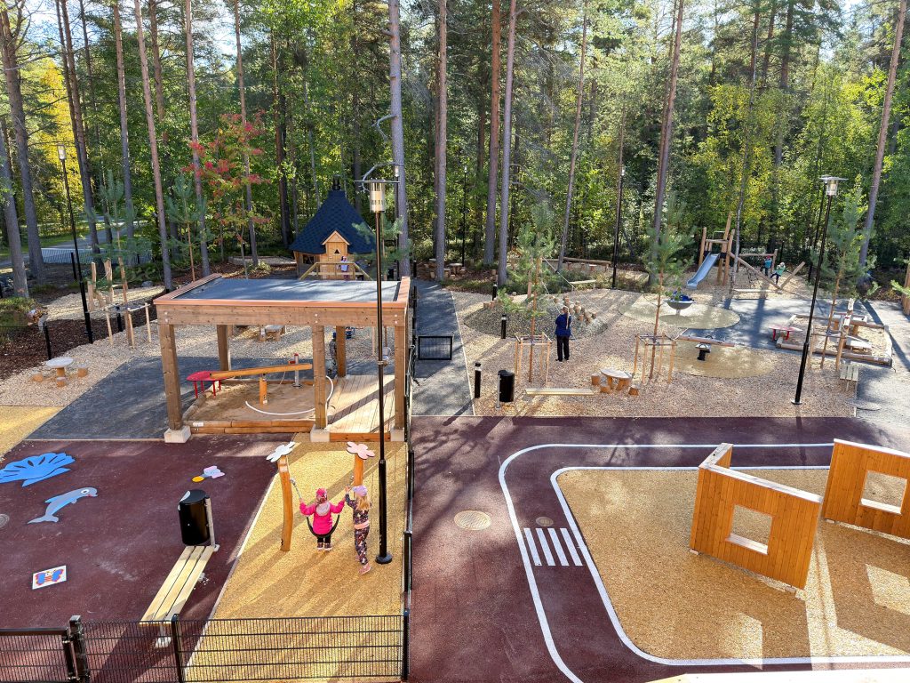 Leikkipuisto, taustalla metsää.