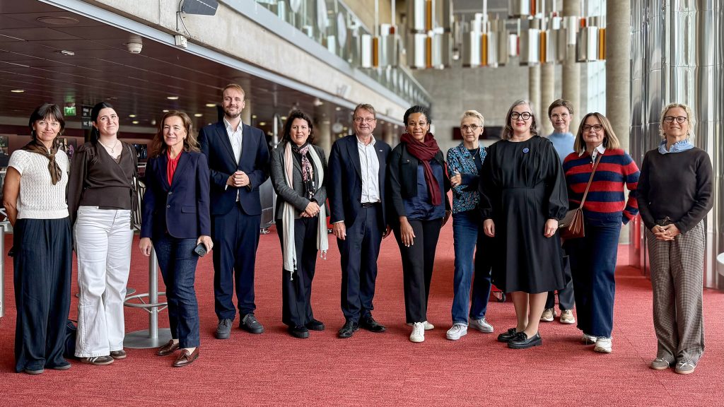 Group of people posing in a theater lobby.