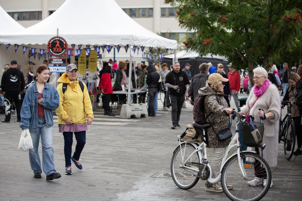 Ihmisiä toriaukiolla, taustalla telttoja.