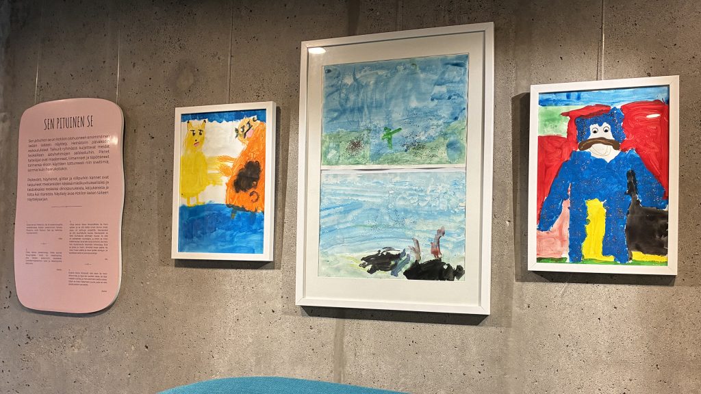 Lasten taideteoksia seinällä.